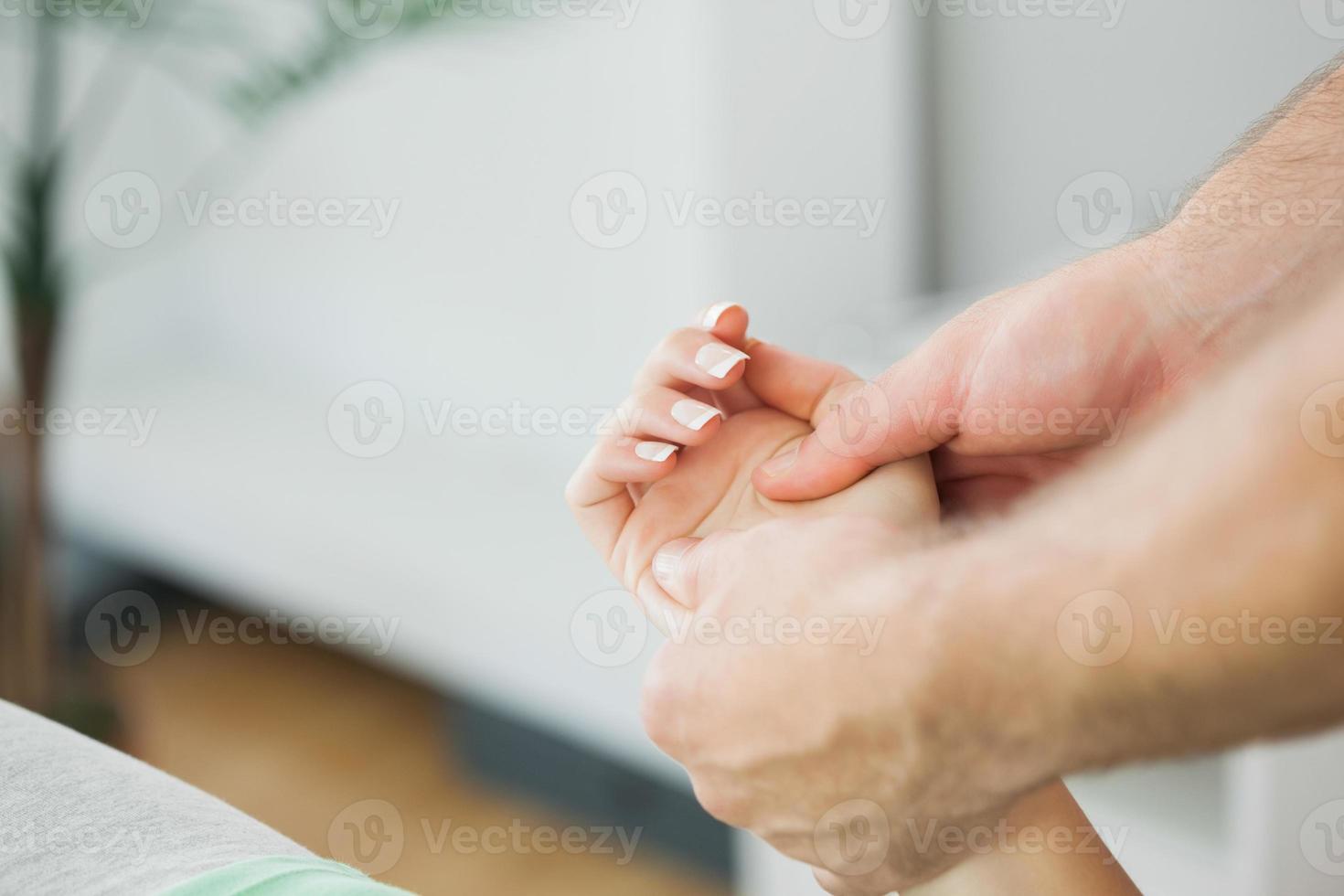 Fisioterapista che massaggia la mano di un paziente foto