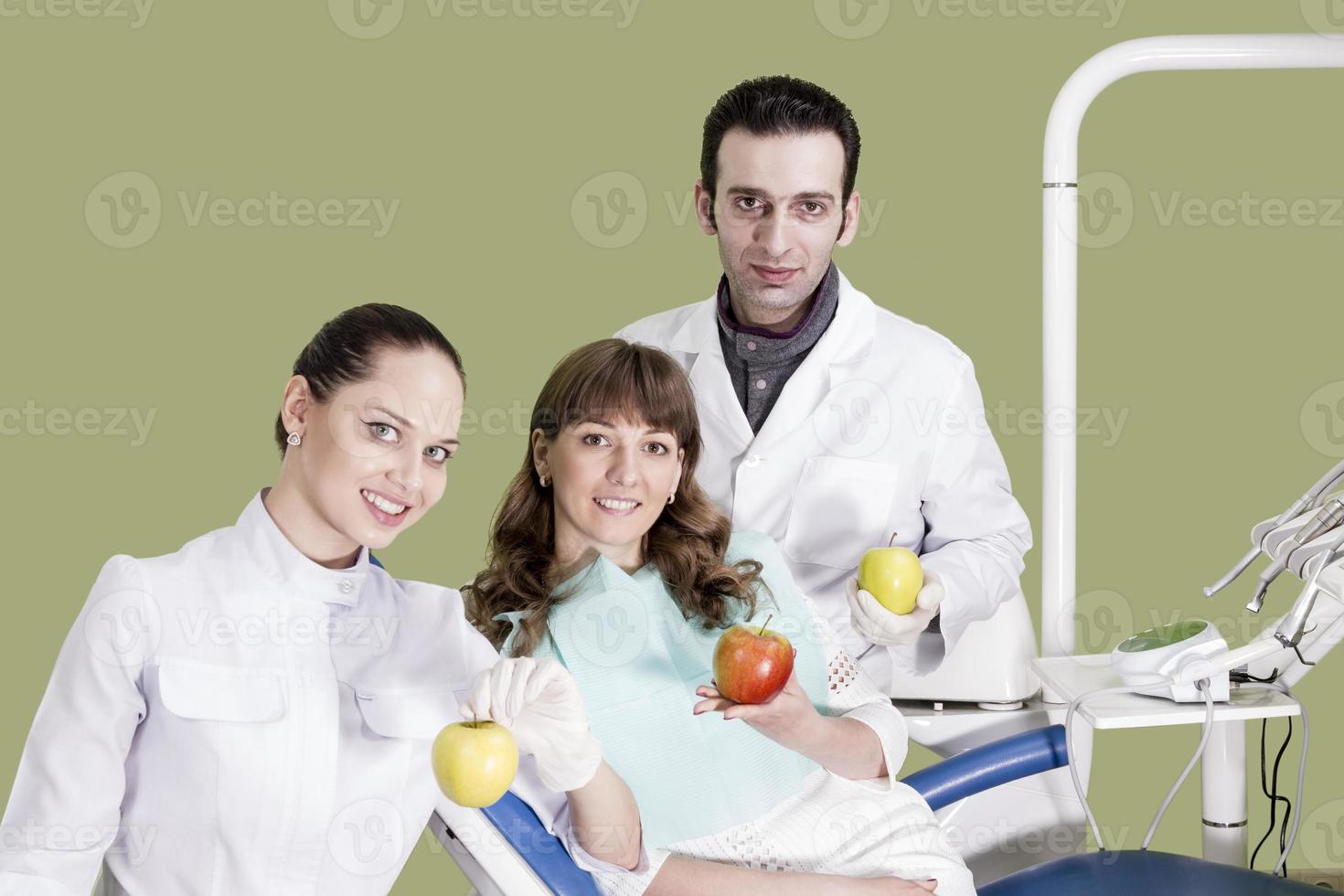 l'assistente dentista e il paziente tengono in mano la mela foto