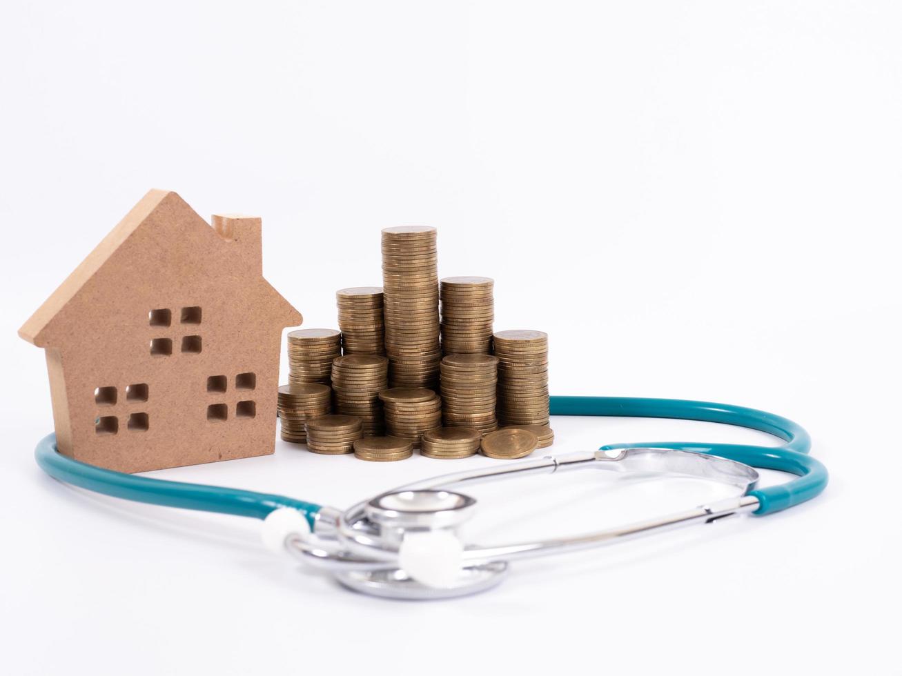 controlla il concetto di casa e investimento. stetoscopio con casa in miniatura e denaro foto
