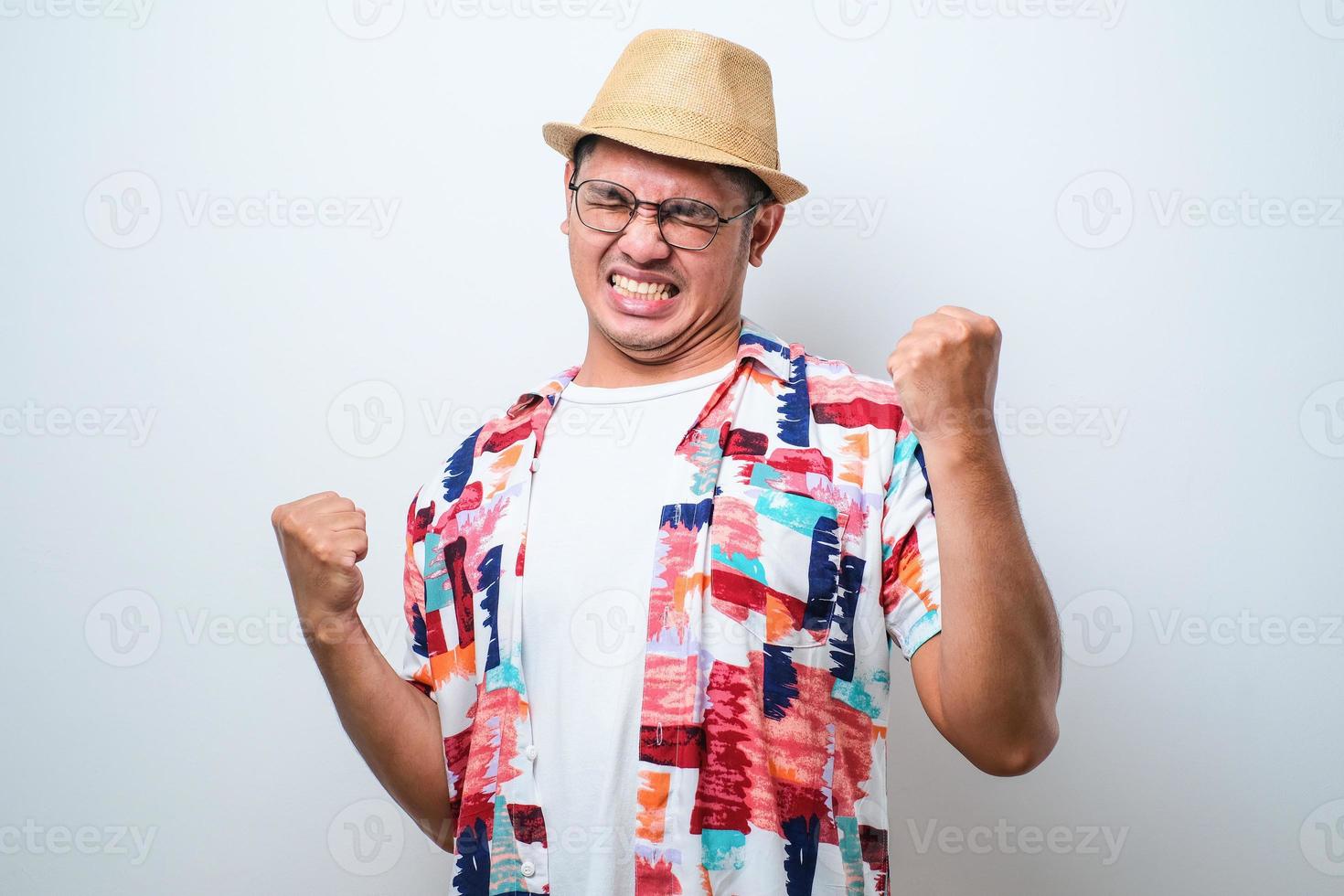 giovane bell'uomo che indossa una camicia da spiaggia casual in piedi molto felice ed eccitato facendo il gesto del vincitore con le braccia alzate foto