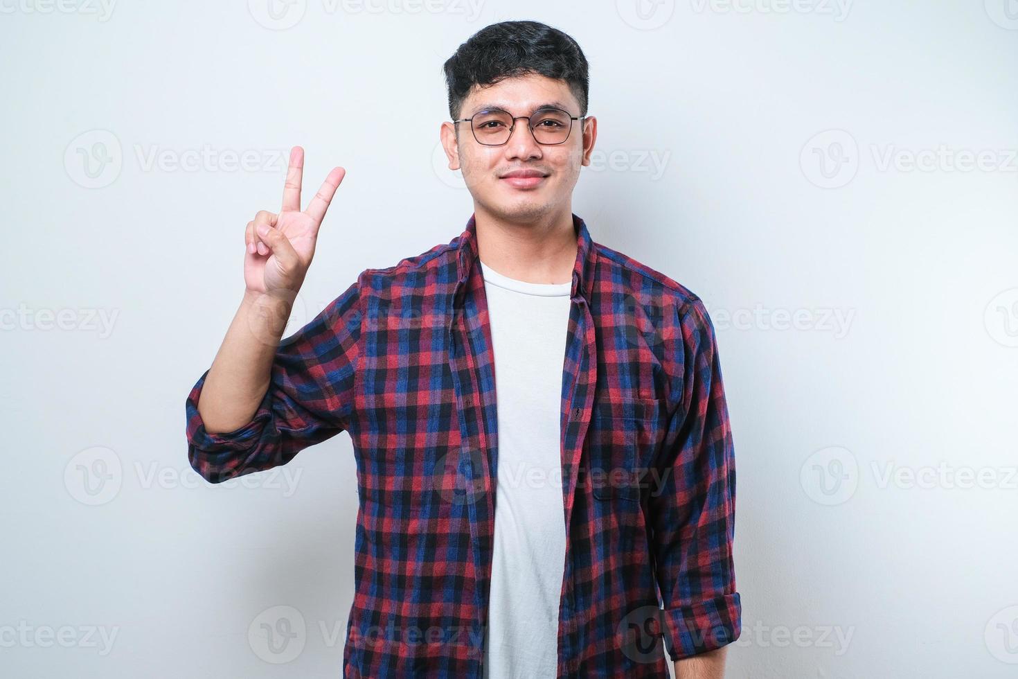 giovane uomo asiatico bello che indossa abiti casual mostrando e puntando verso l'alto con le dita numero due mentre sorride fiducioso e felice foto