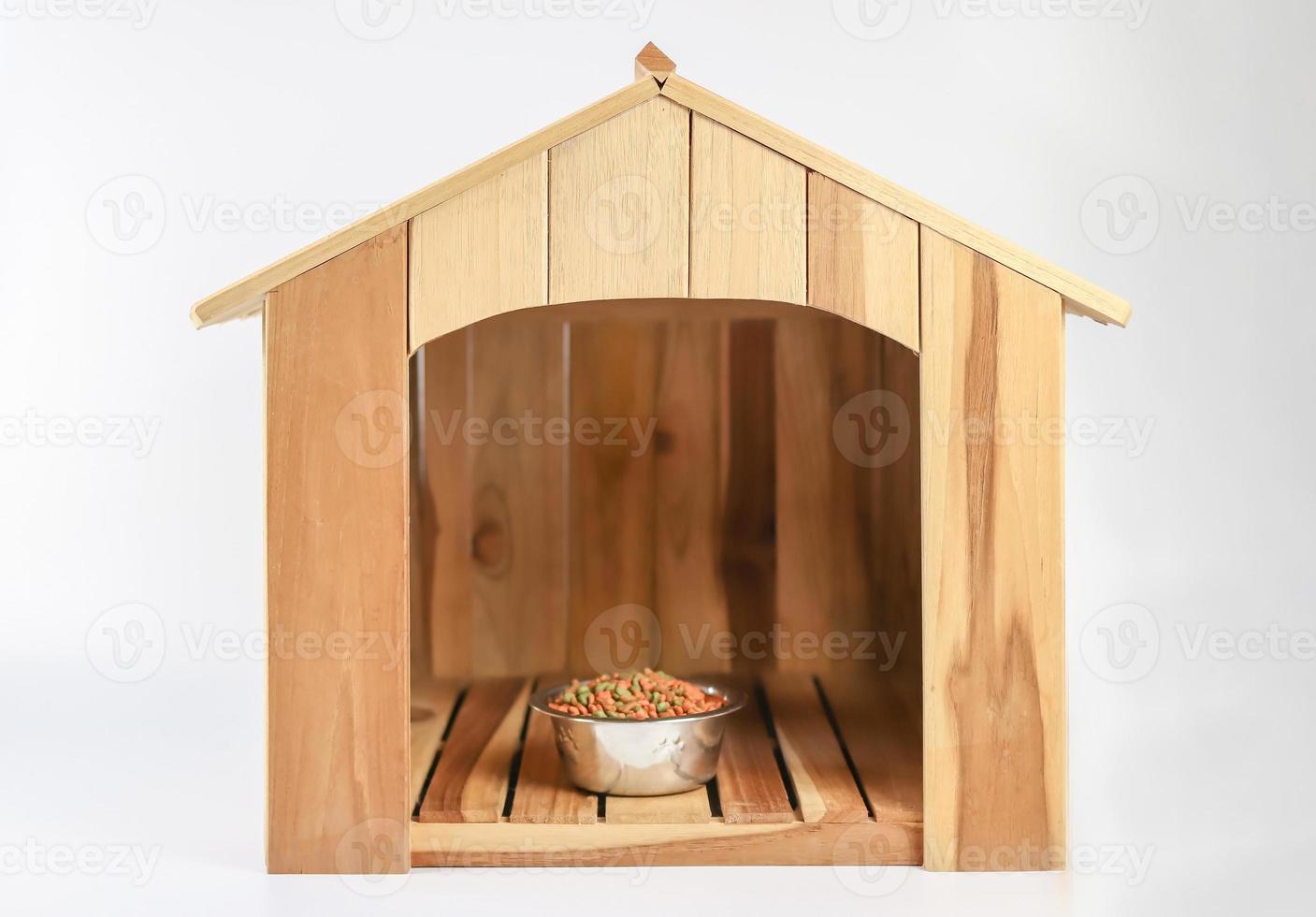 casa del cane in legno con ciotola di cibo per cani all'interno, su sfondo bianco. isolato. foto