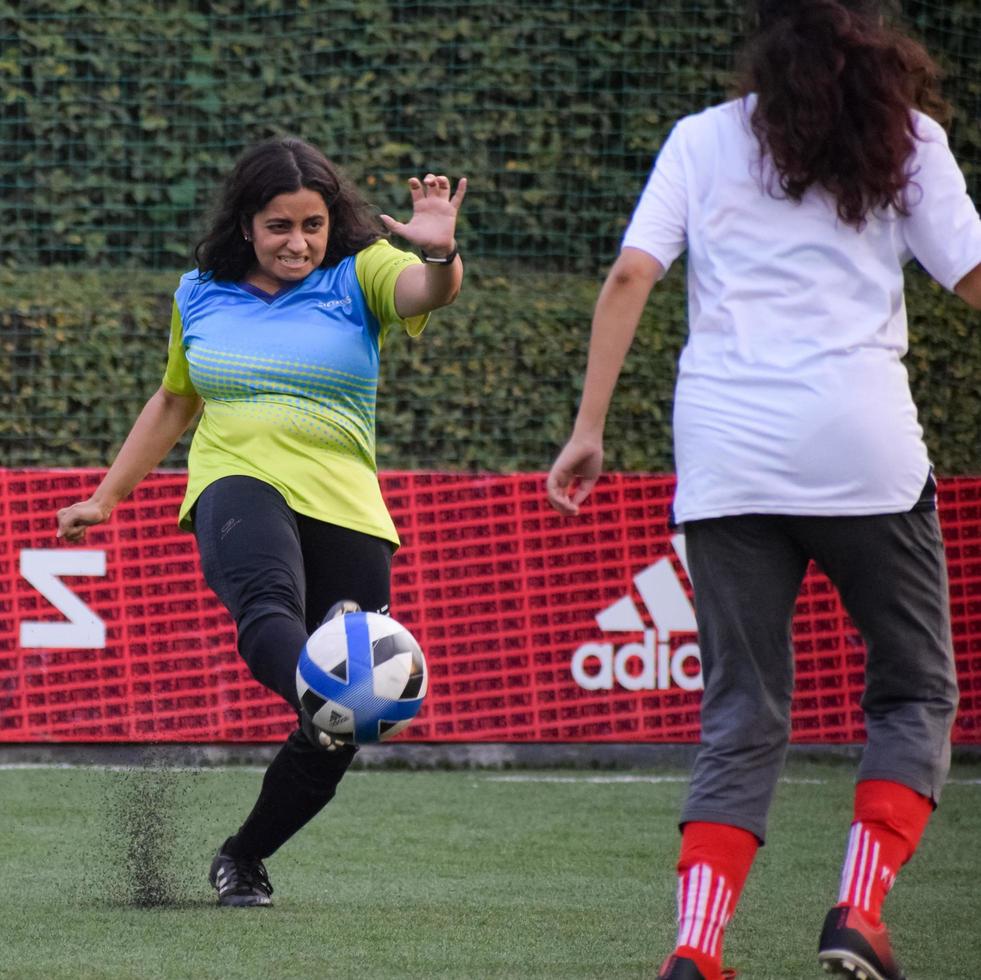 nuova delhi, india - 01 luglio 2018 - calciatrici della squadra di calcio locale durante la partita nel campionato regionale di derby su un brutto campo da calcio. momento caldo della partita di calcio sullo stadio del campo verde erba foto