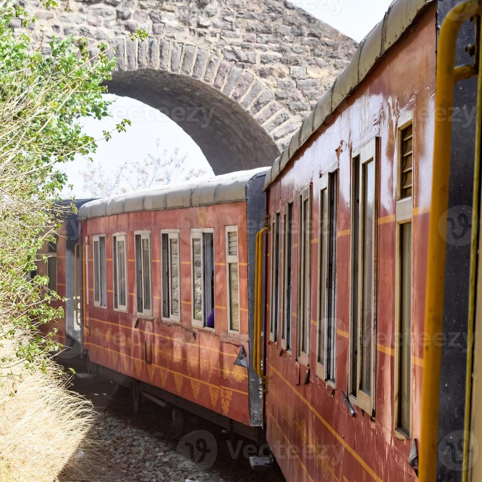 trenino che si muove sui pendii delle montagne, bella vista, un lato della montagna, un lato della valle che si muove sulla ferrovia verso la collina, tra il verde della foresta naturale. trenino da kalka a shimla in india, treno indiano foto