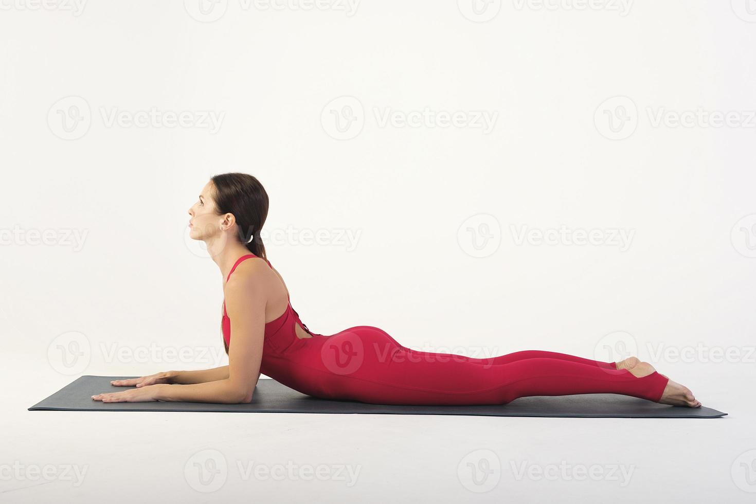 una ragazza affascinante mostra asana di stretching e yoga in uno studio fotografico foto