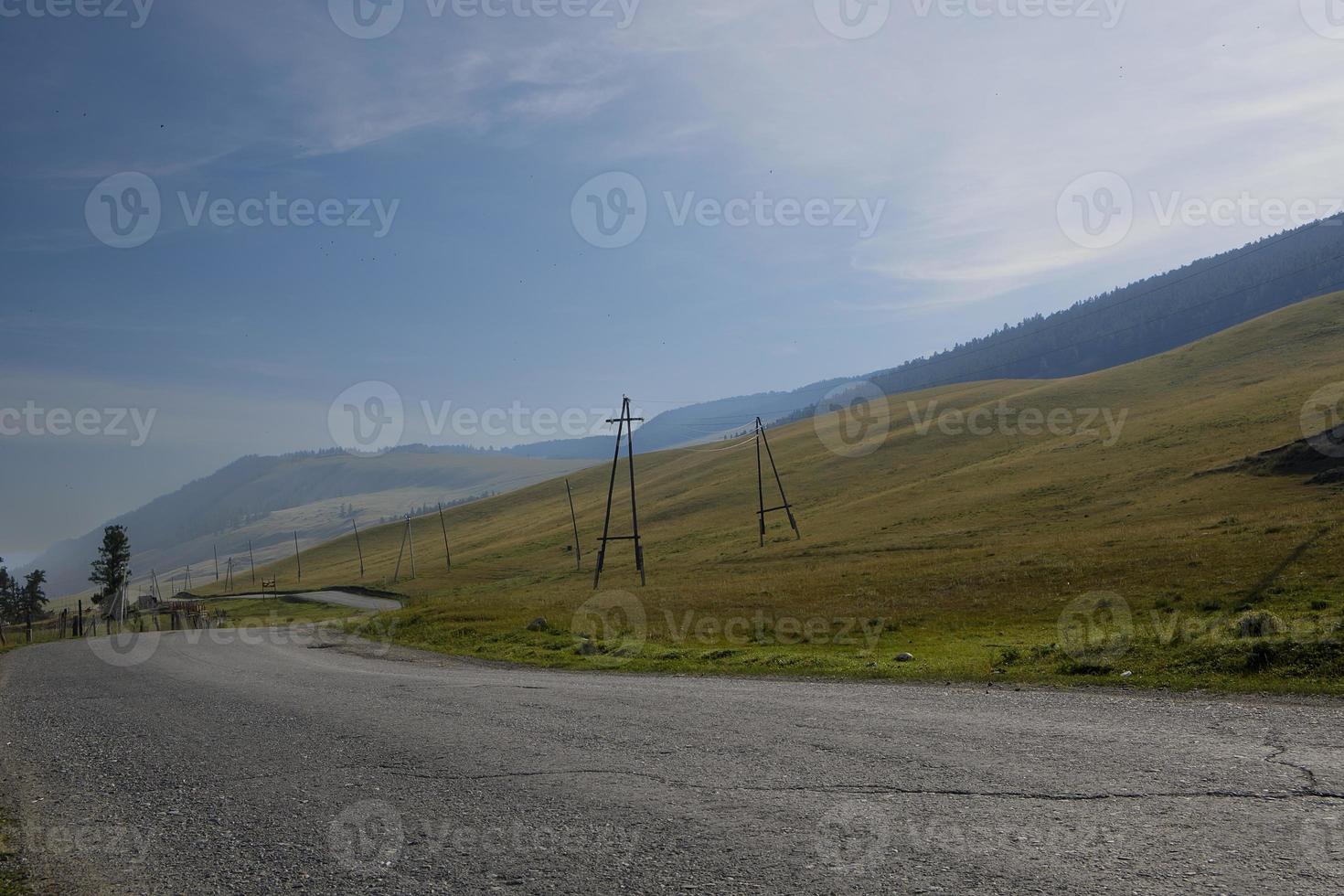 nastro di strada tra le pendici dei monti sulle distese di altai in una giornata estiva foto