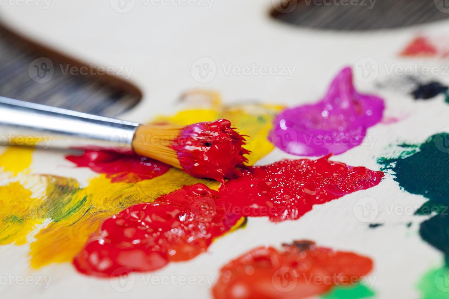 mescolato su una tavolozza di legno di vernici multicolori foto