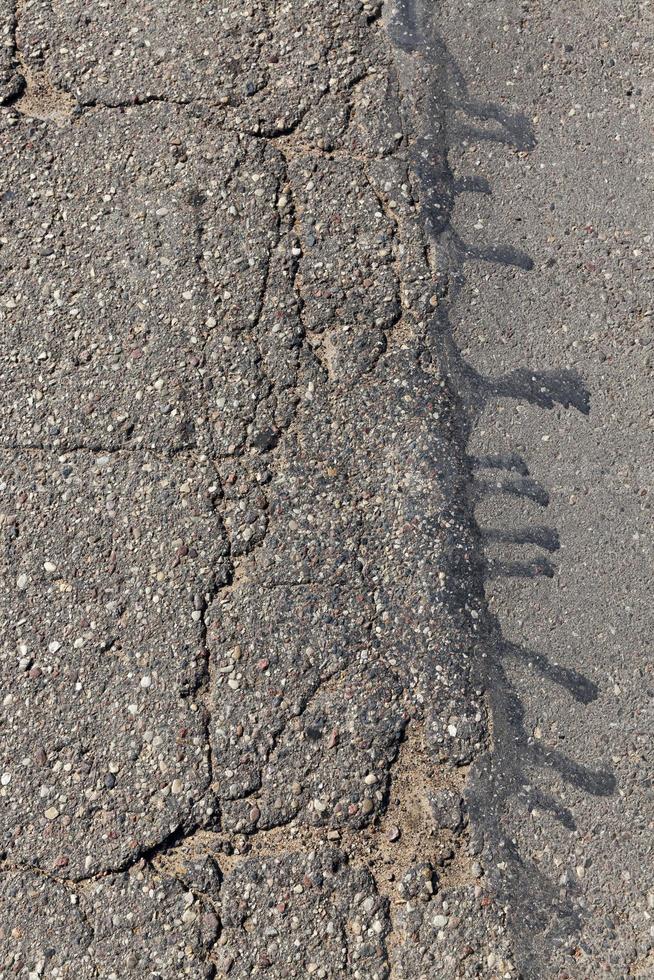 una strada asfaltata con molte buche e buche foto