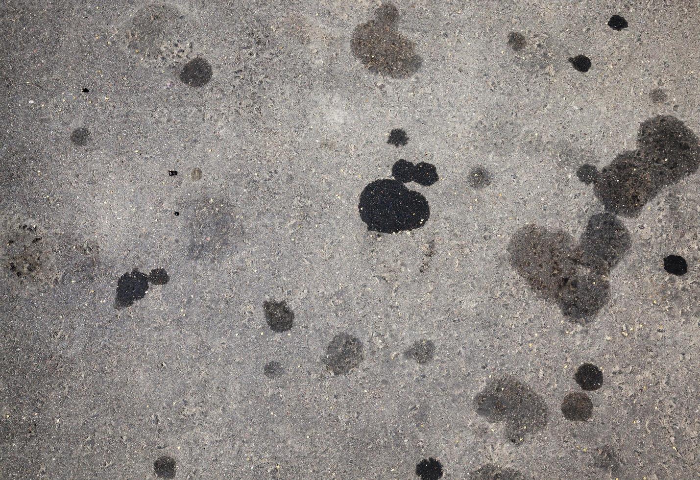 macchie di olio per auto su una strada asfaltata foto