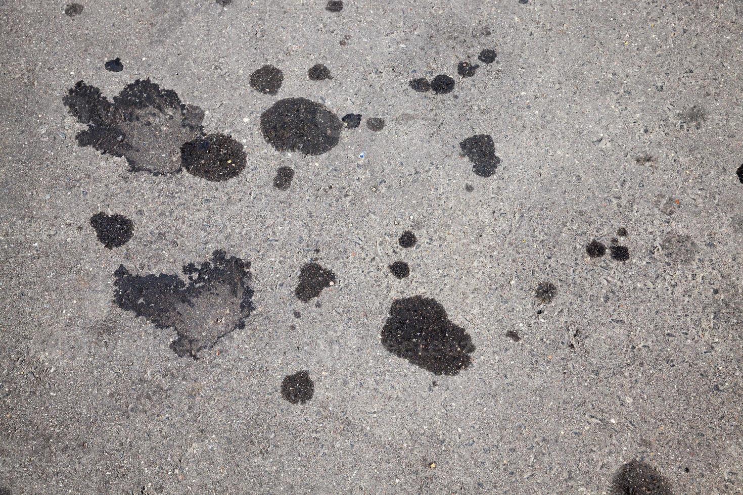 macchie di olio per auto su una strada asfaltata foto