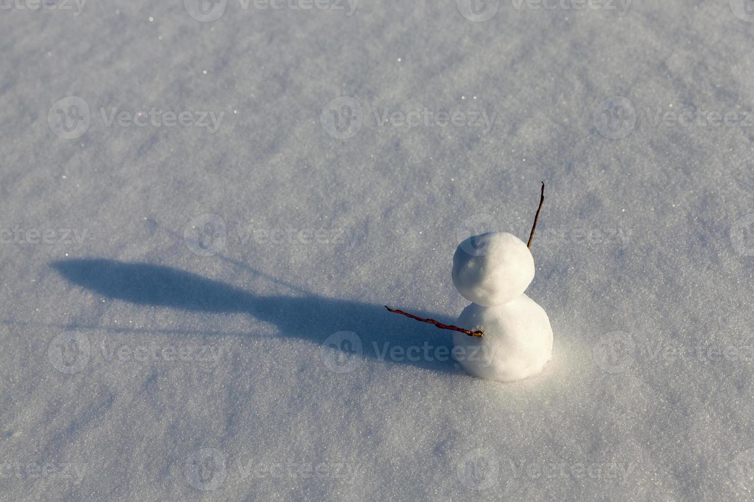 un piccolo pupazzo di neve nella stagione invernale, primo piano foto