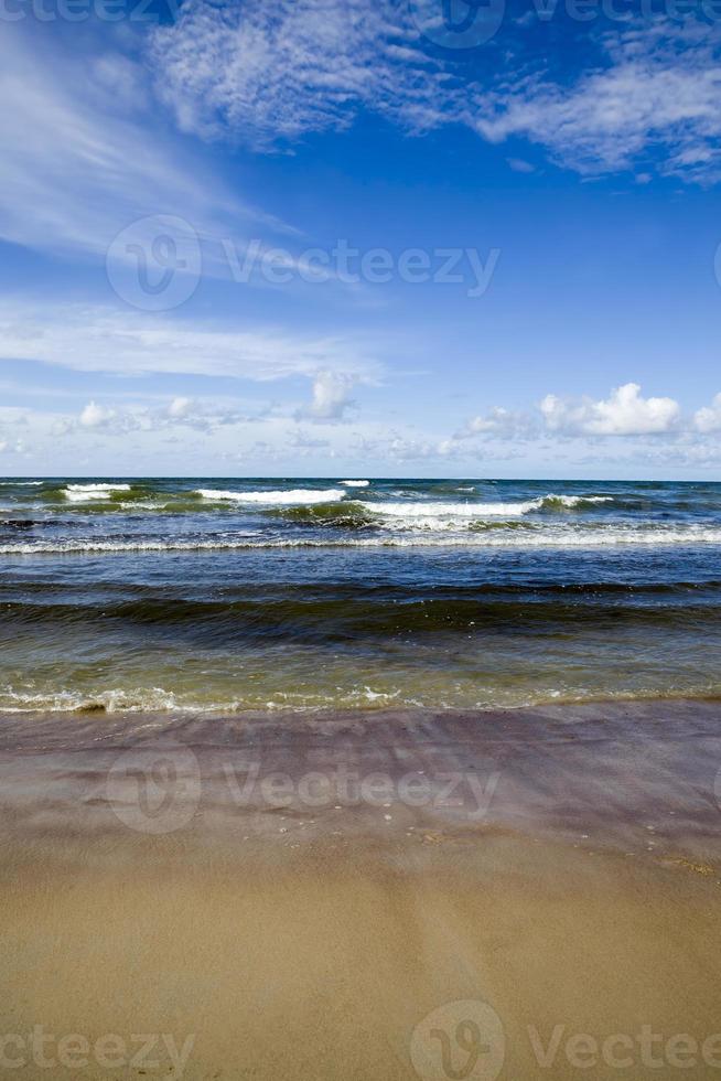 costa del mare con molte onde dal tempo ventoso foto