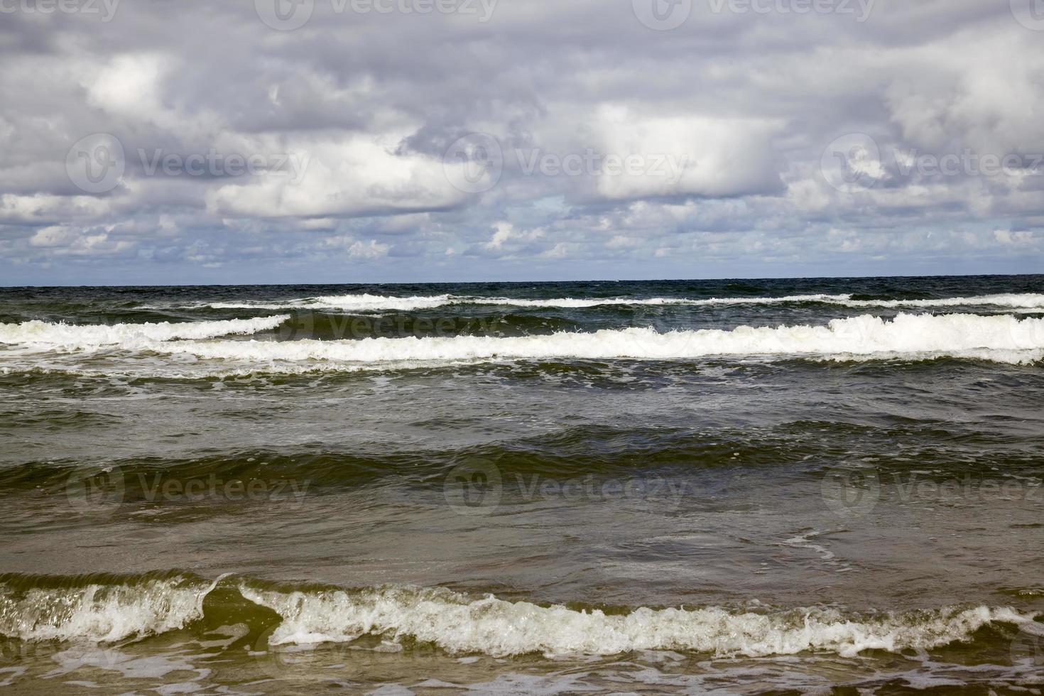 costa del mare con molte onde dal tempo ventoso foto