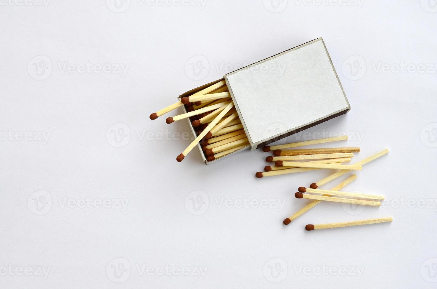 scatola di fiammiferi di cartone aperta piena di fiammiferi su sfondo bianco foto