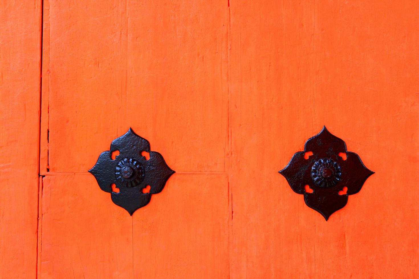 porta in legno vintage rossa o arancione per sfondo con simbolo in acciaio inossidabile nero. carta da parati in legno retrò con linea di spazio incrinato e copia foto