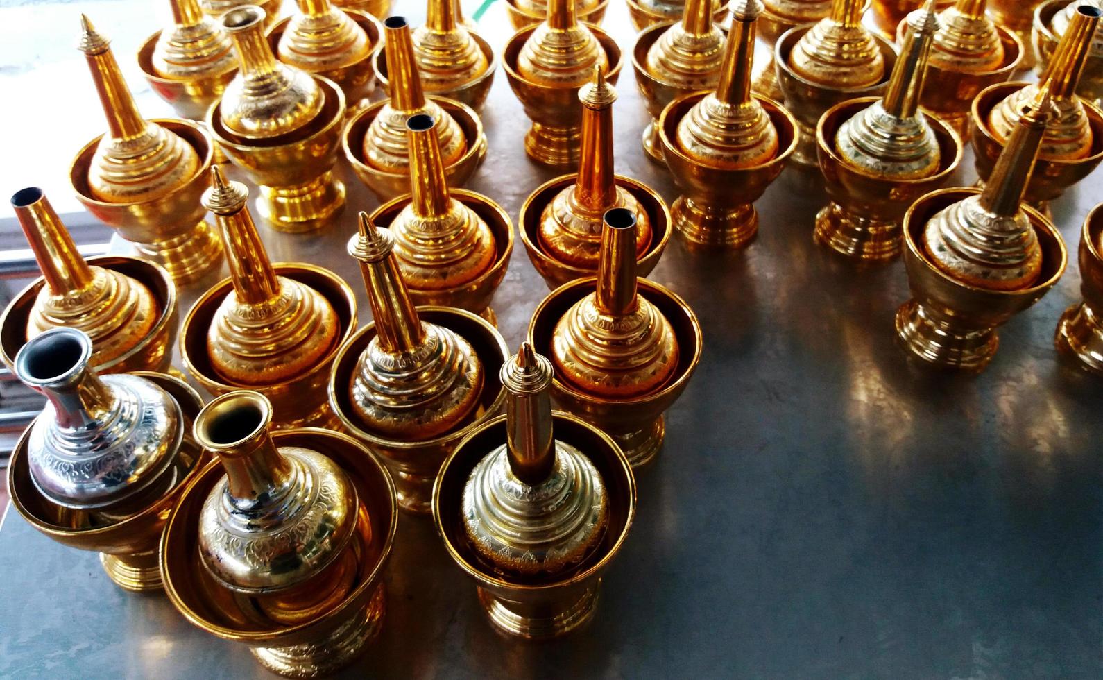 bottiglia d'oro e ciotola per versare l'acqua dopo aver fatto merito con i monaci nel tempio tailandese. foto