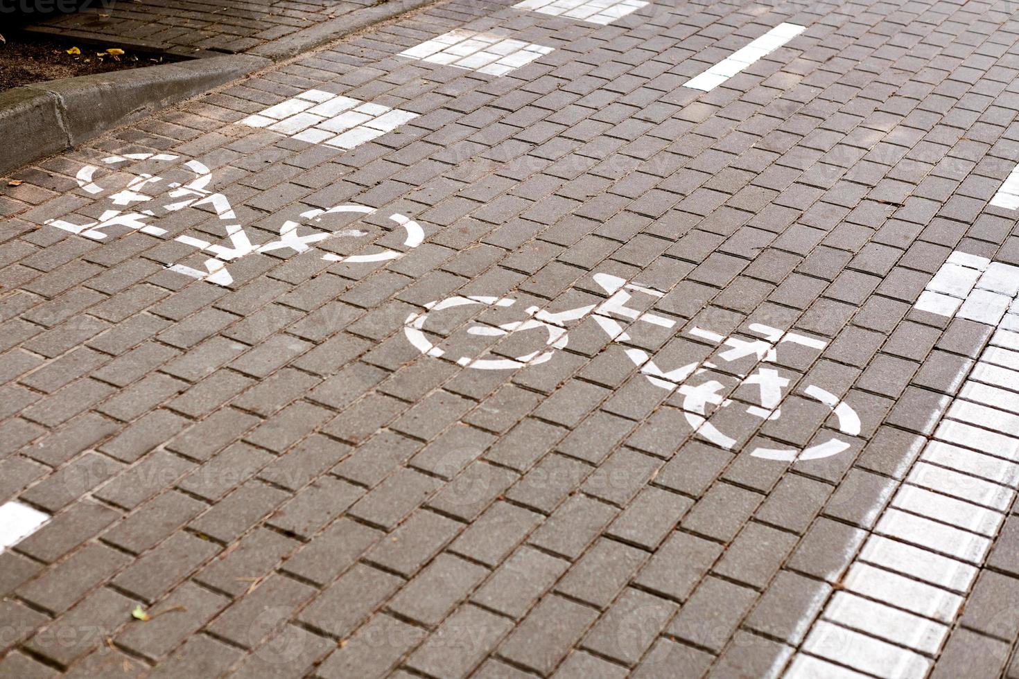 pista ciclabile a doppio senso, segnaletica pista ciclabile sul marciapiede, cartello bicicletta dipinto di bianco su strada, simbolo ciclo foto