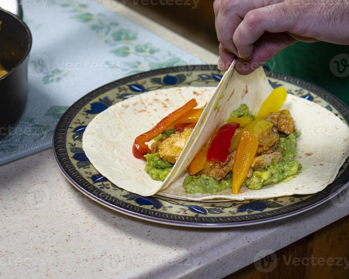 il cuoco mostra involucri di tortilla placcati foto