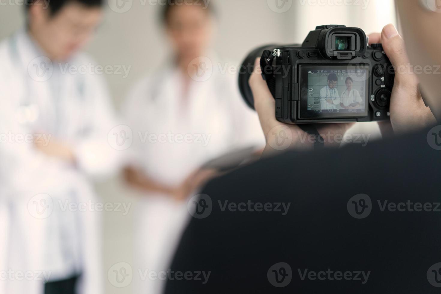 fotografo che scatta filmati sul concetto di medici e infermieri in vendita sul sito web foto