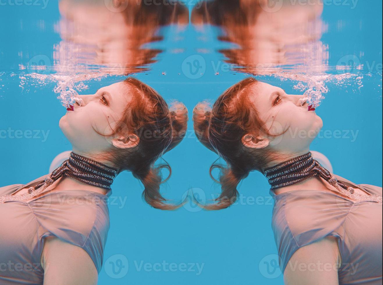 ritratto di arte surreale di giovane donna in abito grigio e sciarpa di perline sott'acqua in piscina foto