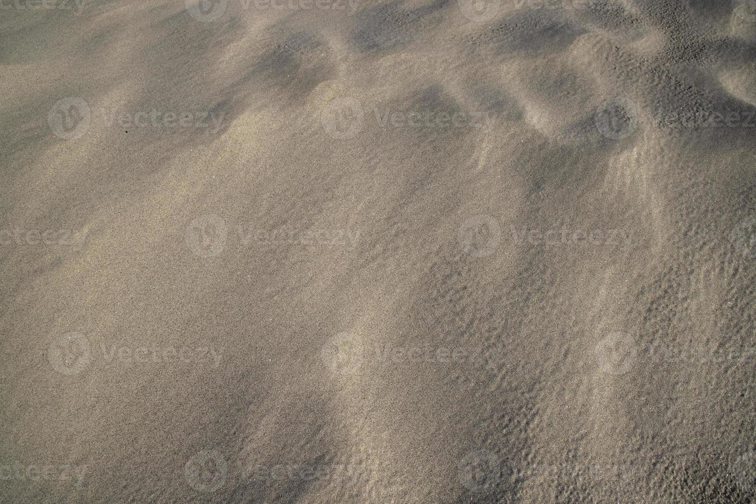 consistenza della sabbia. sfondo strutturato di sabbia ondulata. spiaggia di sabbia strutturata foto