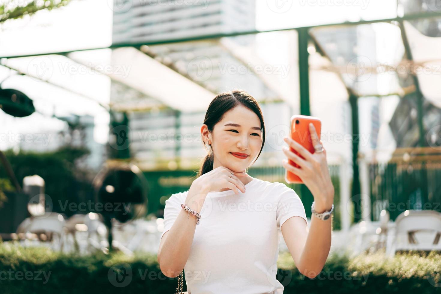 giovane donna single adulta asiatica di affari che utilizza la videochiamata del telefono cellulare con un amico. foto