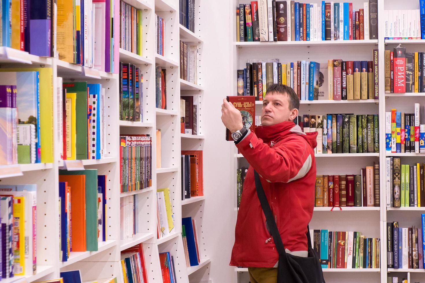 ivanovo, russia, 21 febbraio 2021, un uomo sceglie un libro in libreria, editoriale foto