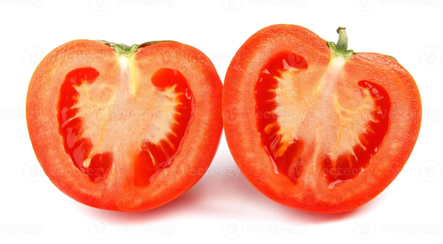 il pomodoro maturo tagliato in due metà viene isolato su uno sfondo bianco. foto