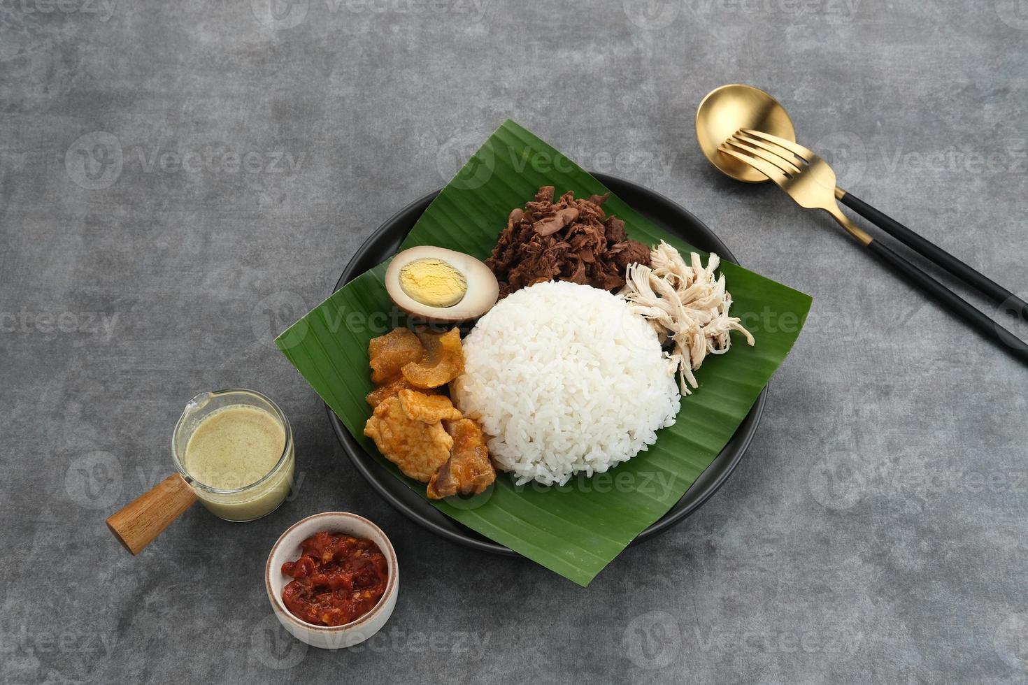 gudeg, un alimento tipico di Yogyakarta, indonesia, a base di giovani jackfruit cucinati con latte di cocco. servito con spezzatino piccante di cracker di pelle di bovino, uova marroni, pollo grattugiato e sambal. foto