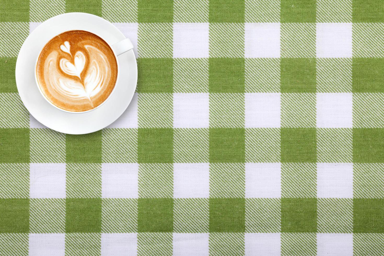vista dall'alto latte art caffè su tessuto texture di sfondo tessile foto