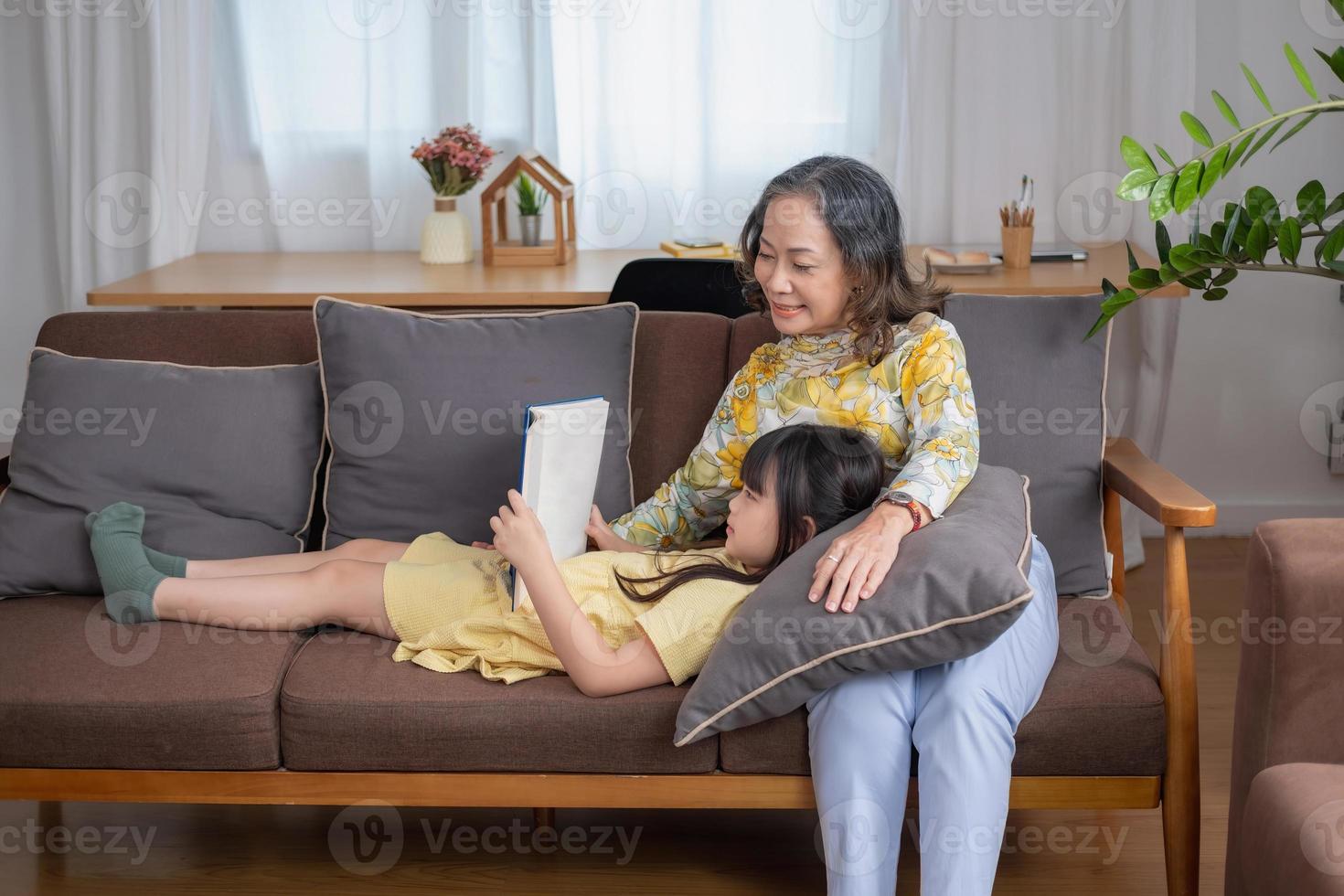 ritratto di una donna anziana e di una nipote che leggono un libro per migliorare le capacità di lettura e le attività familiari. foto