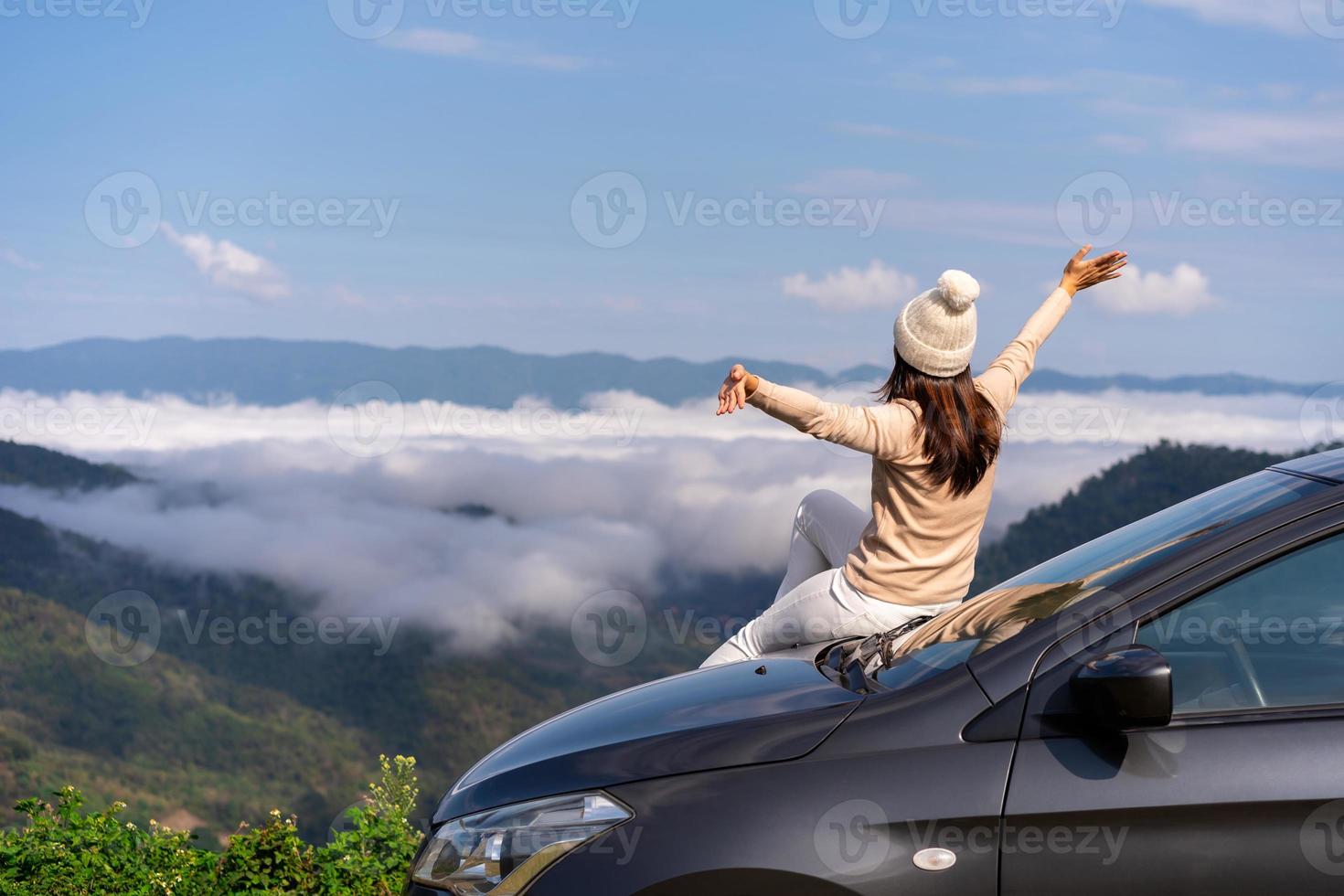 viaggiatori di giovani donne con l'auto che guardano un bellissimo mare di nebbia sulla montagna mentre viaggiano guidando un viaggio su strada in vacanza foto