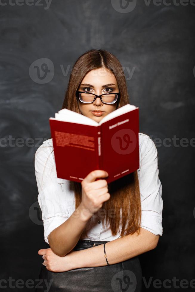 giovane bella studentessa con gli occhiali in possesso di un libro nelle  sue mani 9855955 Stock Photo su Vecteezy