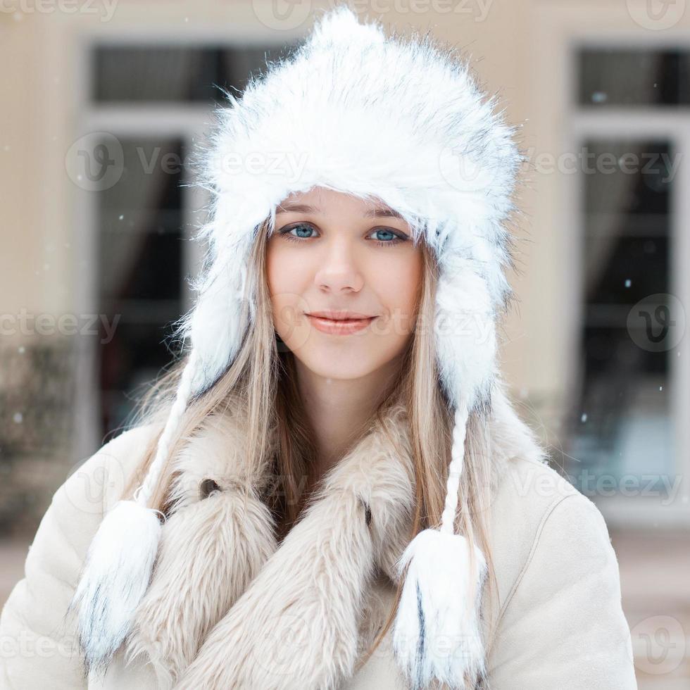 bella ragazza con la giacca invernale in piedi vicino alla casa foto