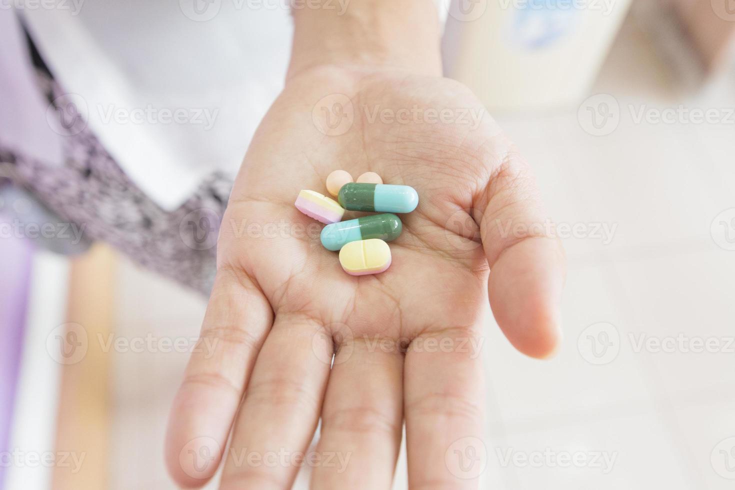 mani del medico che tengono sei pillole foto