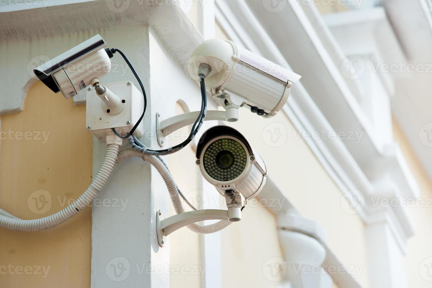 tre telecamere di sicurezza vista frontale sul muro di cemento foto