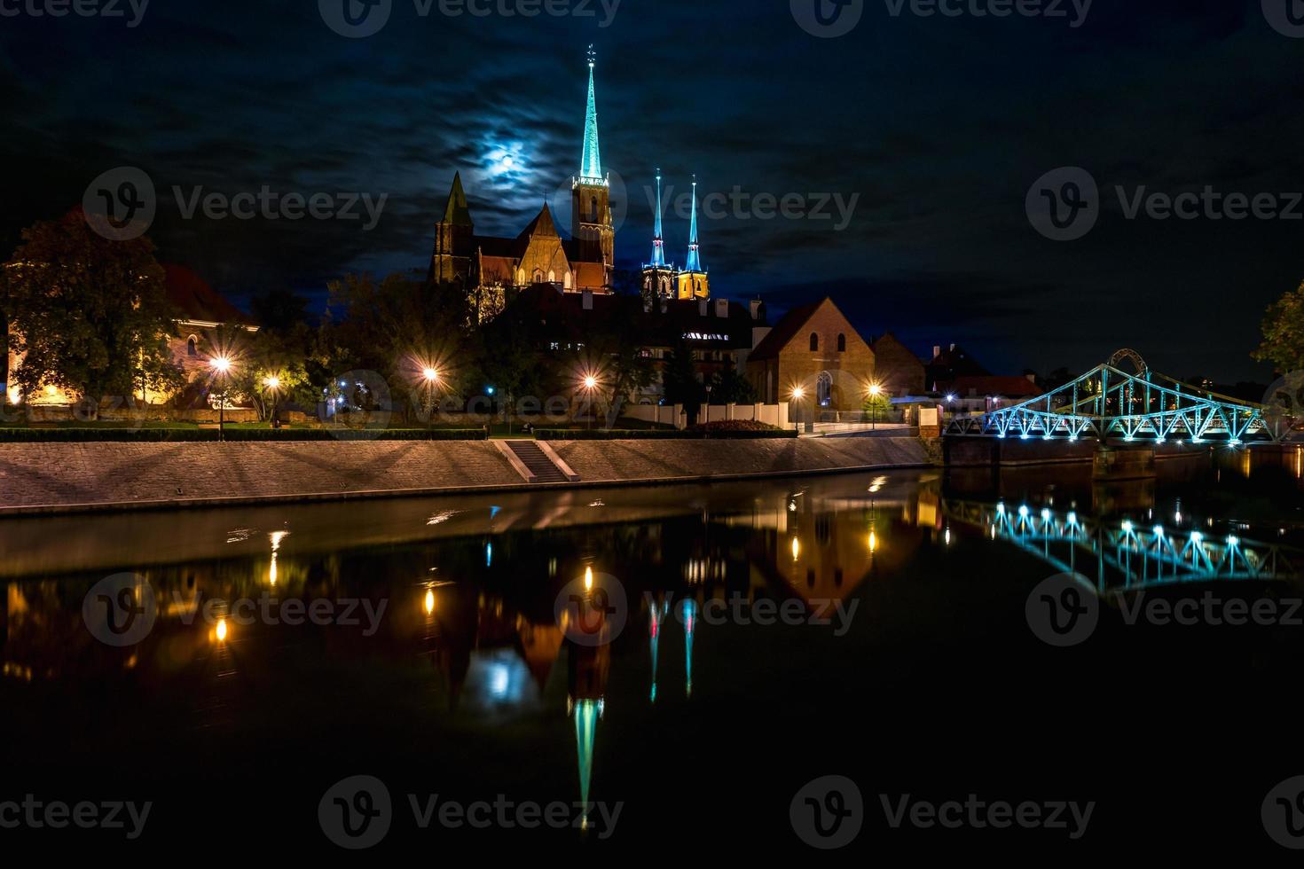 riflessione panoramica con vista lunare della città vecchia architettura e argine del fiume oder e quartiere storico ostrow tumski con le guglie illuminate della cattedrale gotica di wroclaw, polonia foto