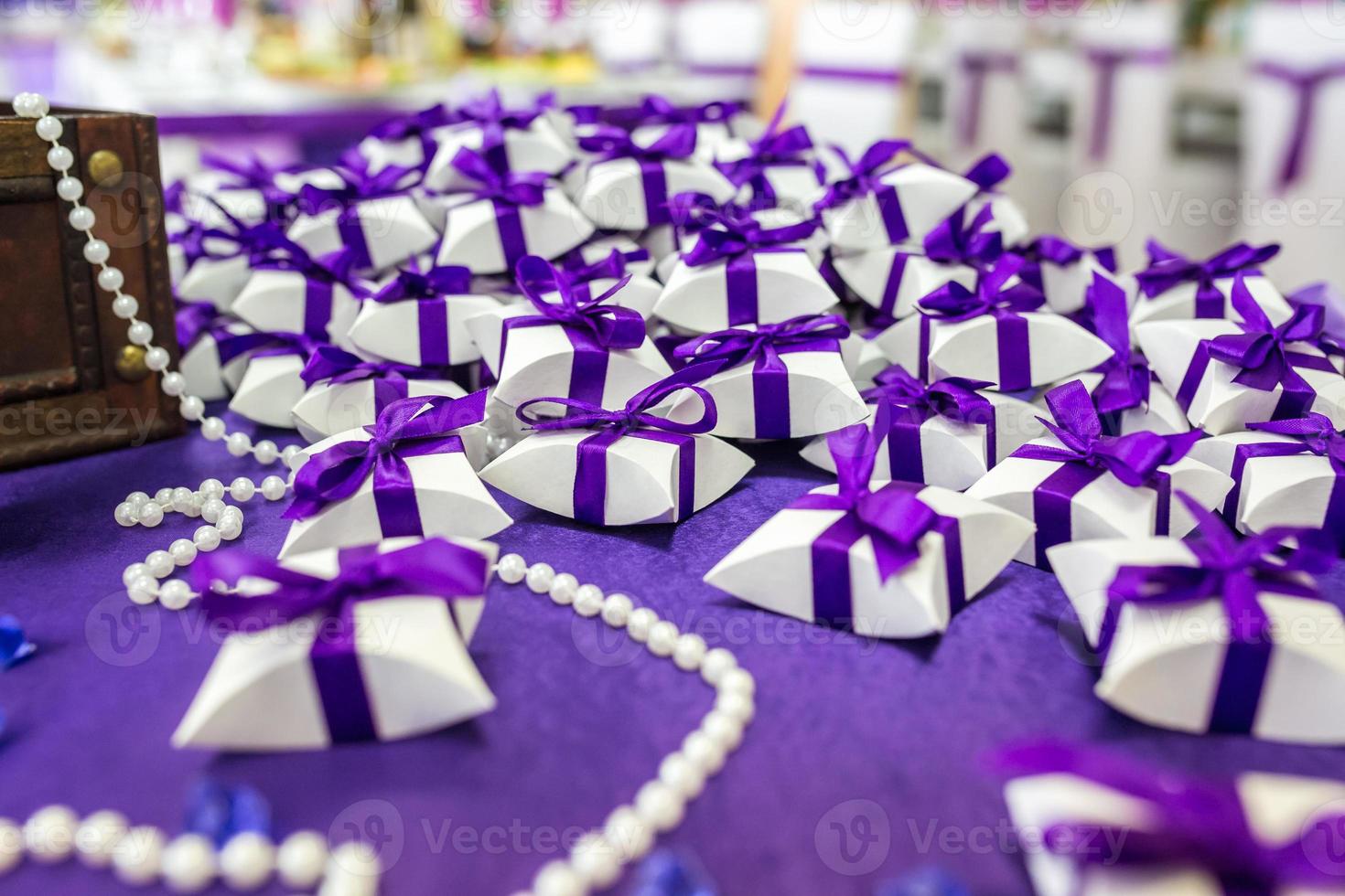 tavola con tovaglia viola e piccoli regali per gli ospiti degli sposi foto