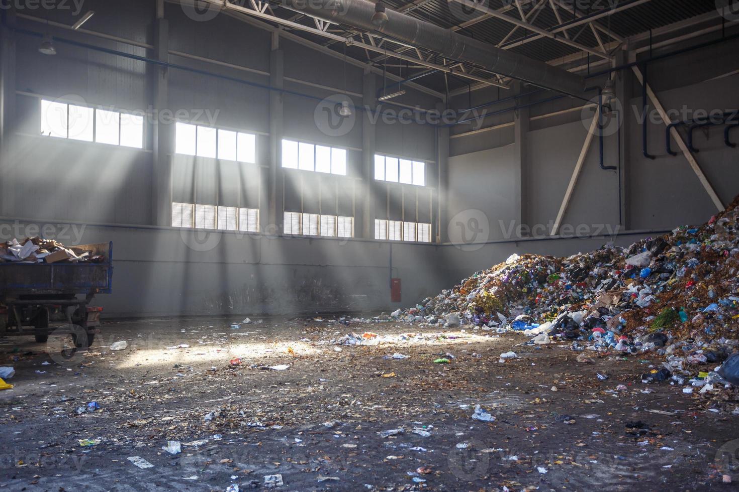 officina di smistamento e riciclaggio dei rifiuti con rimorchio presso l'impianto di trattamento dei rifiuti con raggi solari. raccolta differenziata dei rifiuti. riciclaggio e stoccaggio dei rifiuti per ulteriore smaltimento. foto