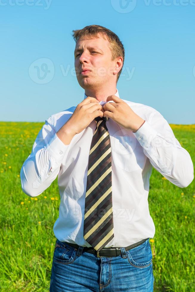 ritratto di un uomo d'affari, raddrizza la cravatta in campo foto