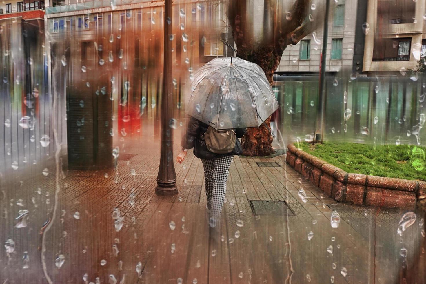 bilbao, vizcaya, spagna, 2022 - persone con un ombrello per strada nei giorni di pioggia, stagione autunnale foto