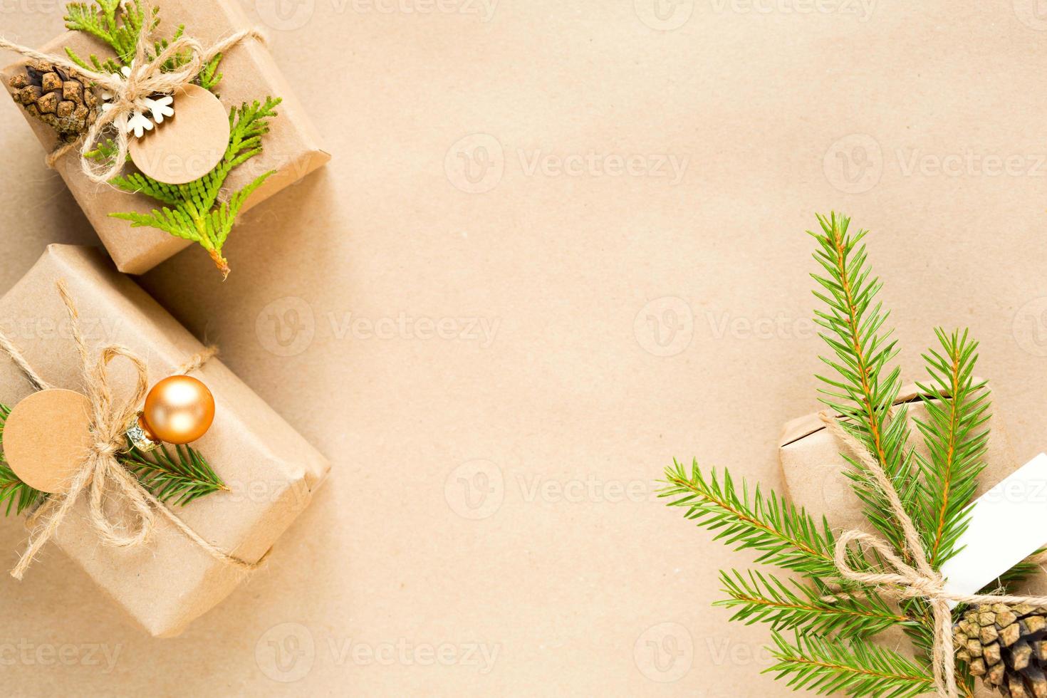 confezione regalo per natale e capodanno in materiali ecologici carta kraft, rami di abete vivo, pigne, spago. tag con mock up, arredamento naturale, fatto a mano, fai da te. piatto, sfondo, cornice, minimalismo foto