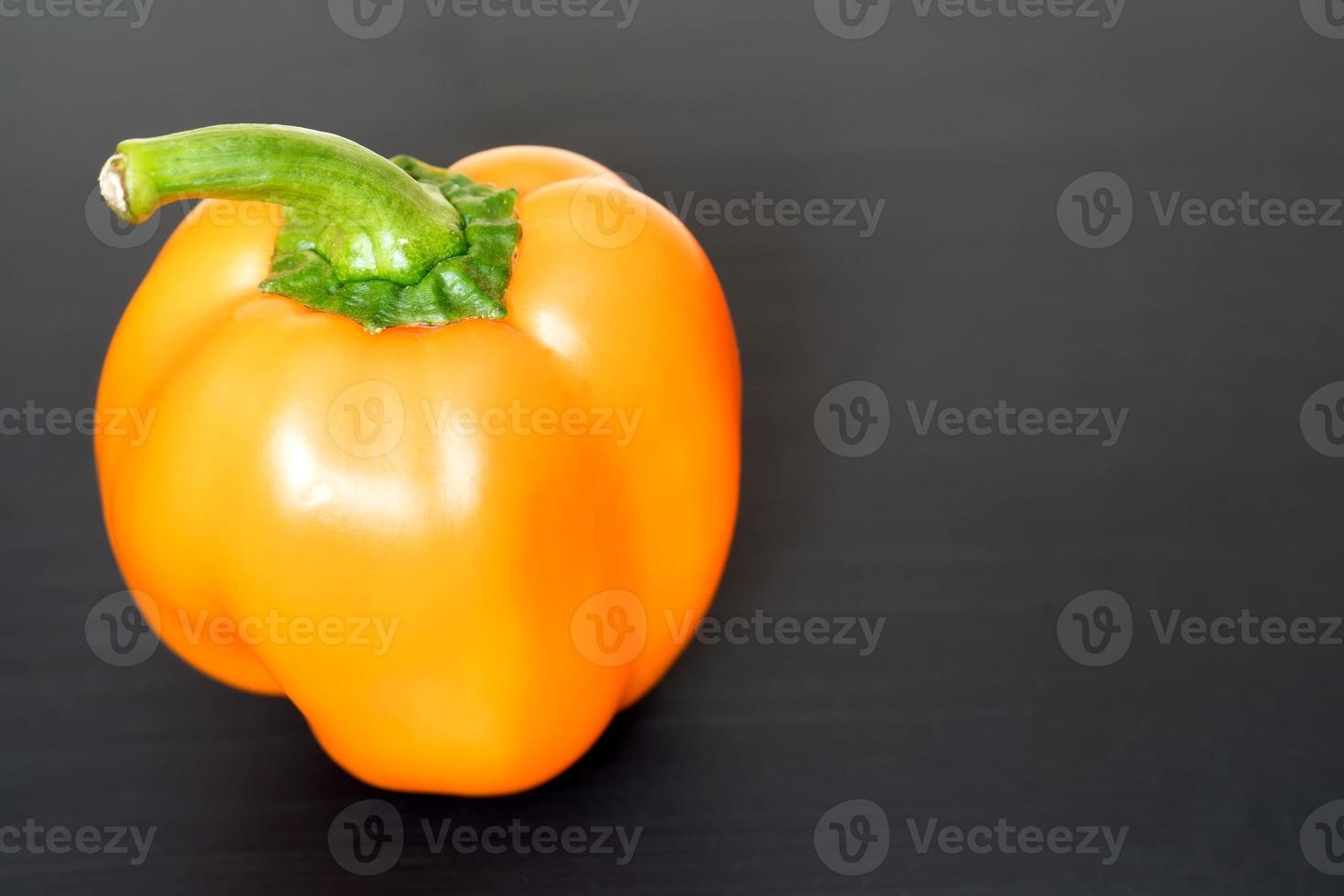 peperone arancione su sfondo nero, copia spazio per il testo foto
