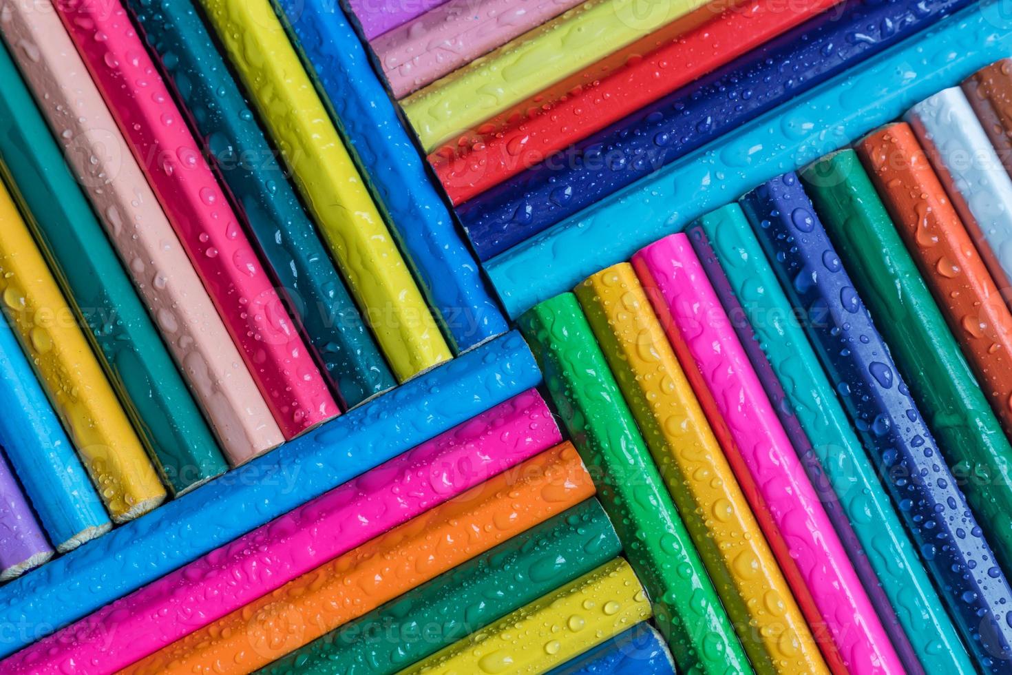 sfondo di matite colorate con goccia d'acqua foto