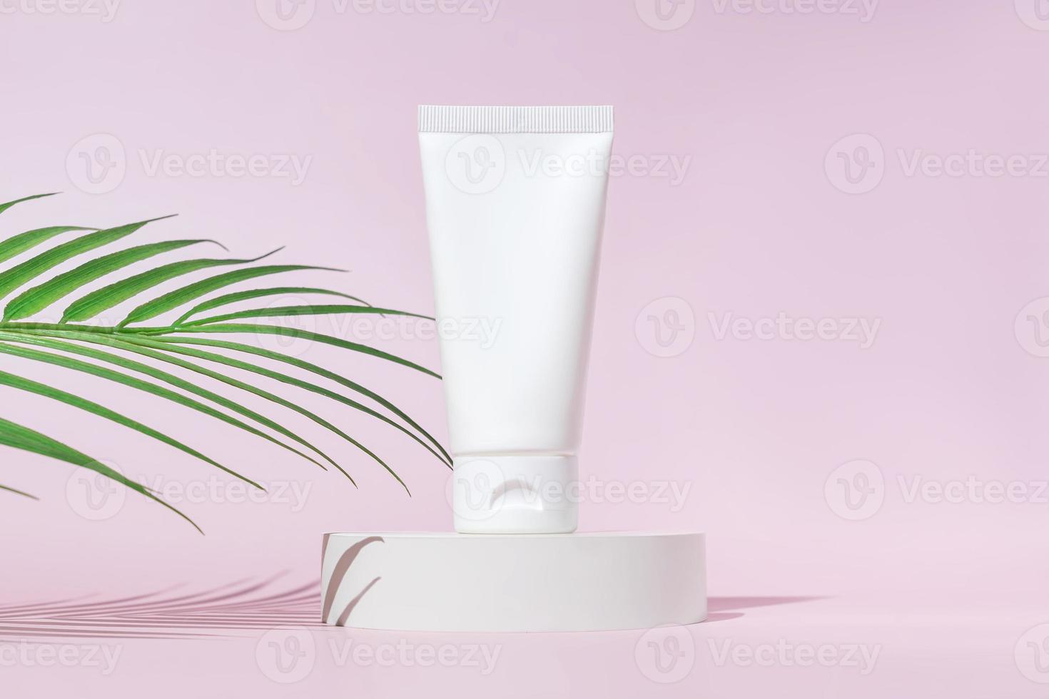 prodotti cosmetici naturali biologici termali con foglie verdi. prodotti di bellezza per la cura della pelle a base di erbe su sfondo rosa. mockup per negozio ecologico o salone di bellezza. stile minimalista, vetrina alla moda foto