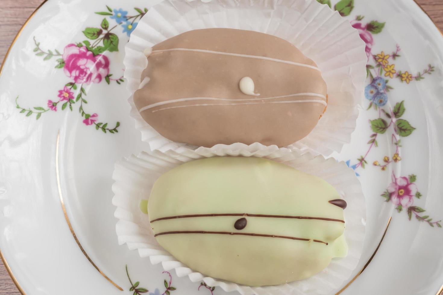 eclair francesi su piatto di porcellana colorato su tavola di legno. vista dall'alto foto