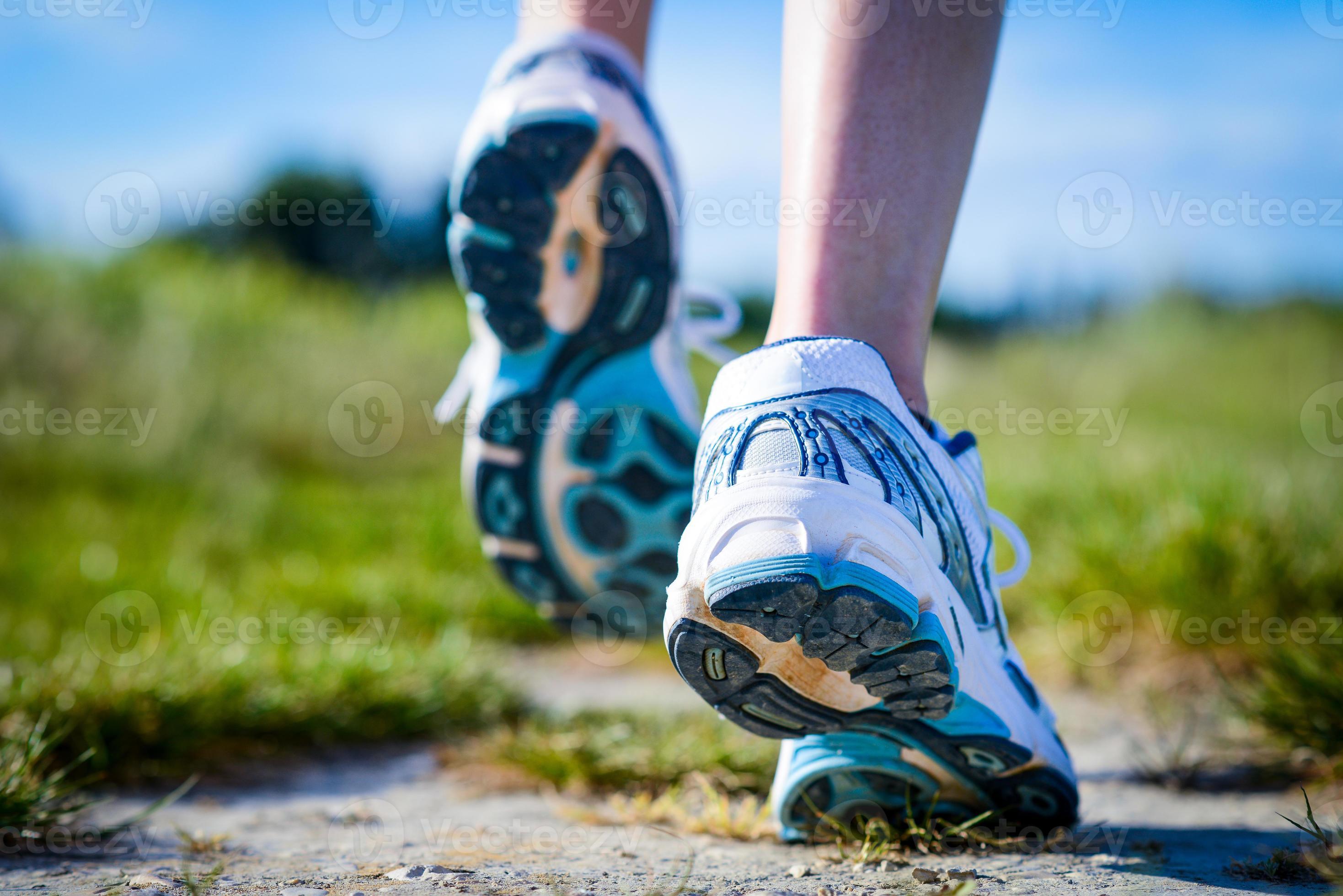 stretta di piedi scarpe da corsa in azione in campagna foto
