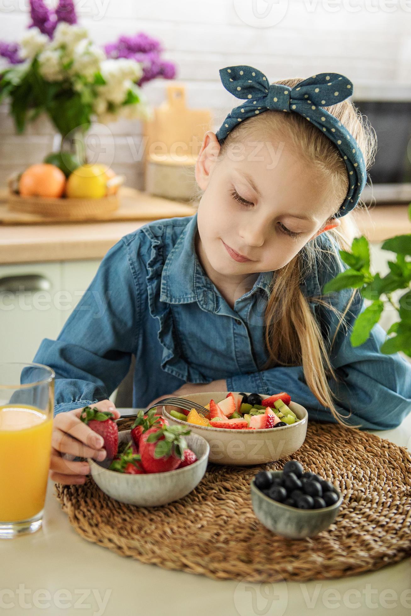 la bambina sveglia mangia la macedonia 13241122 Stock Photo su Vecteezy