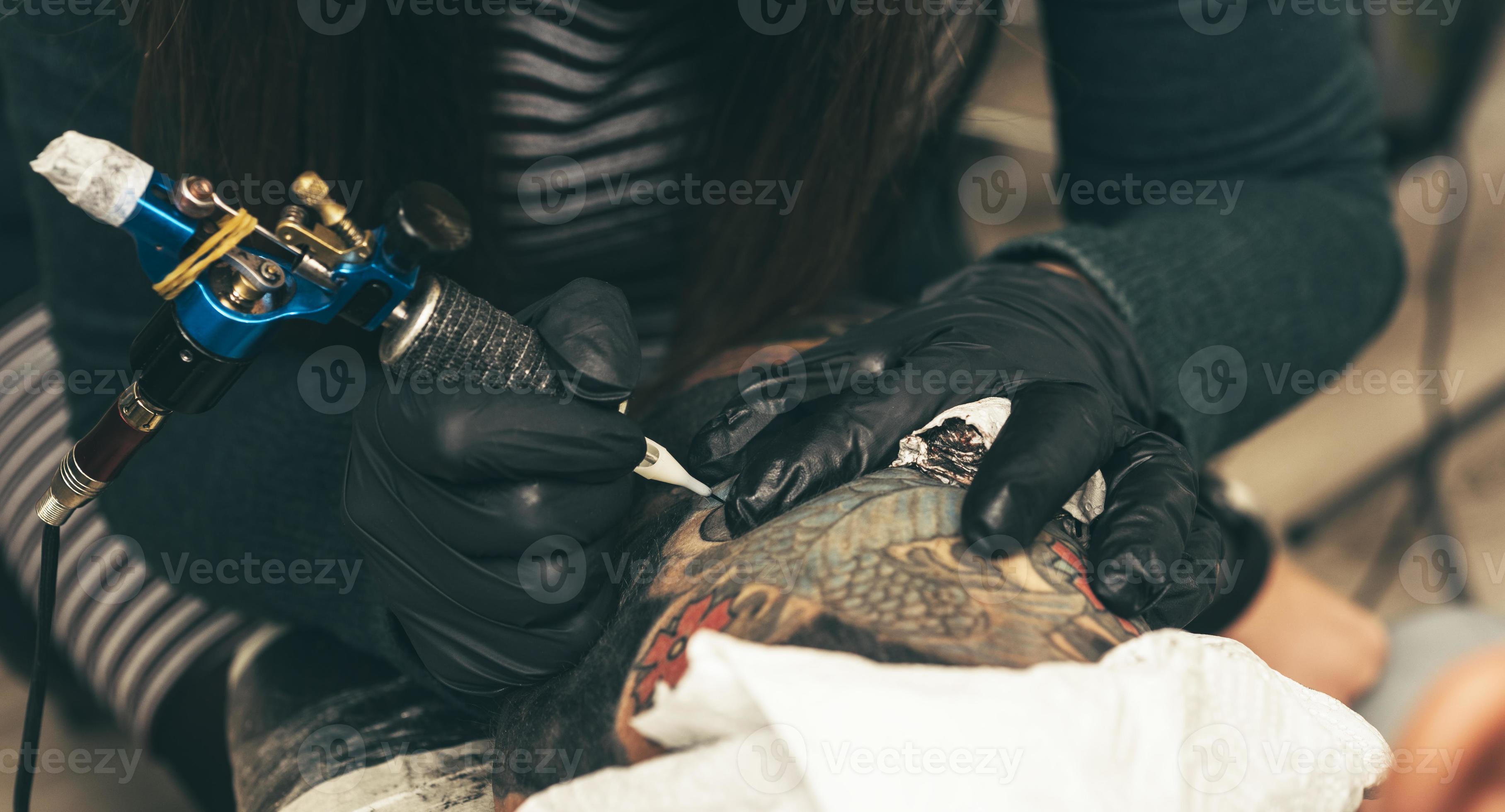 vicino su tatuaggio macchina. uomo la creazione di immagine su mano con  esso nel salone 16689988 Stock Photo su Vecteezy