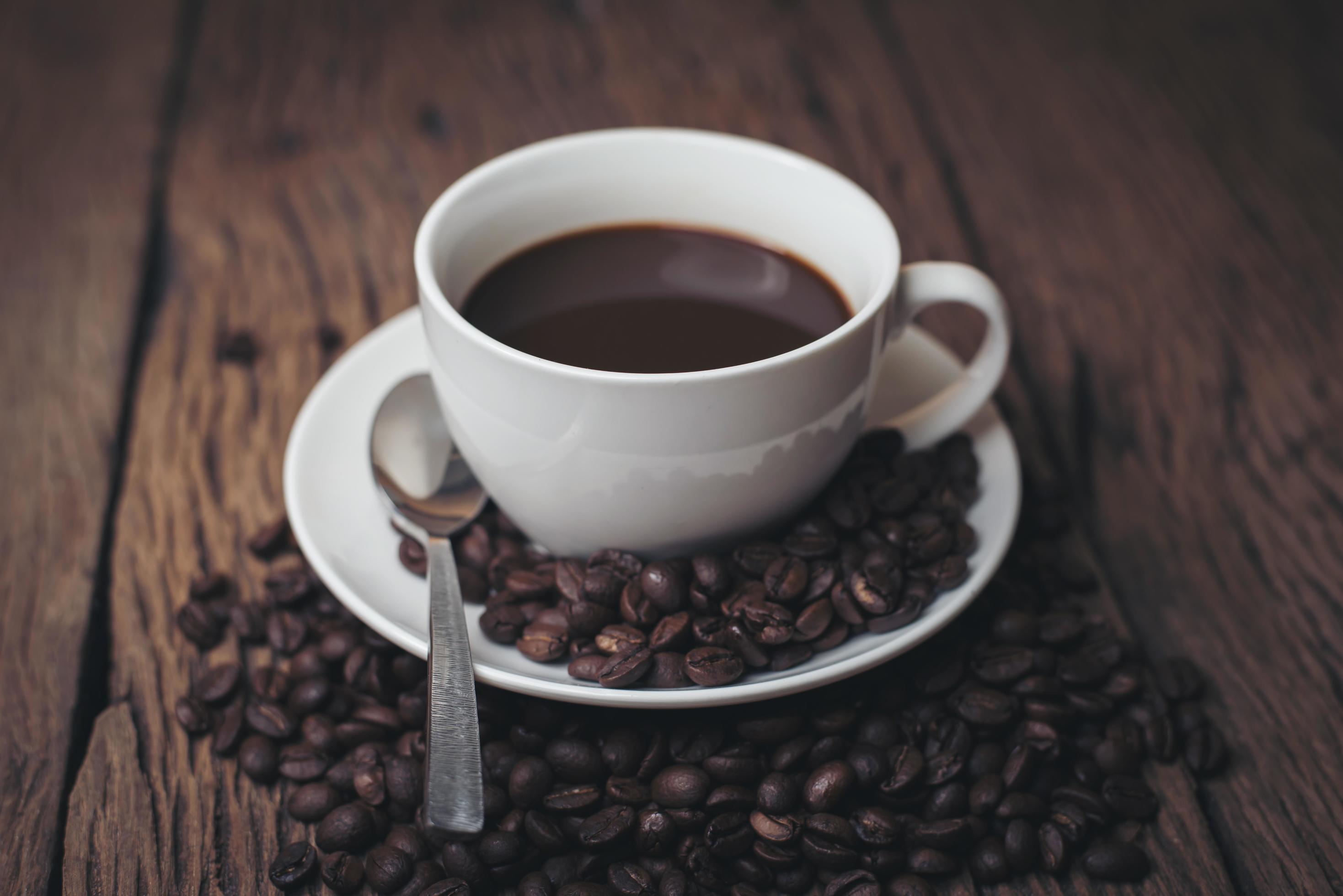 tazza di caffè con chicchi di caffè su un tavolo di legno foto